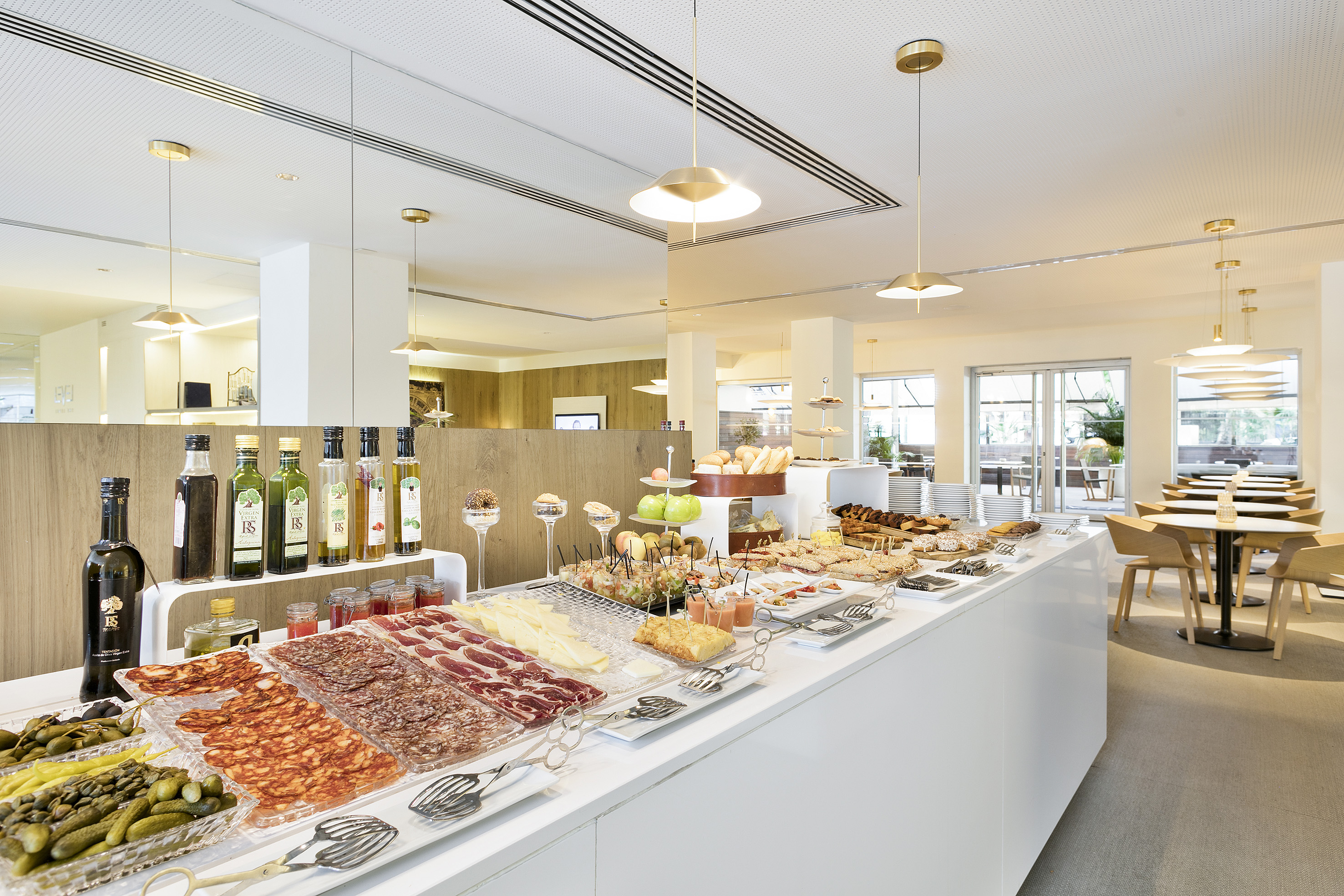 Modern hotel breakfast buffet with cured meats, cheese, and fresh bread.
