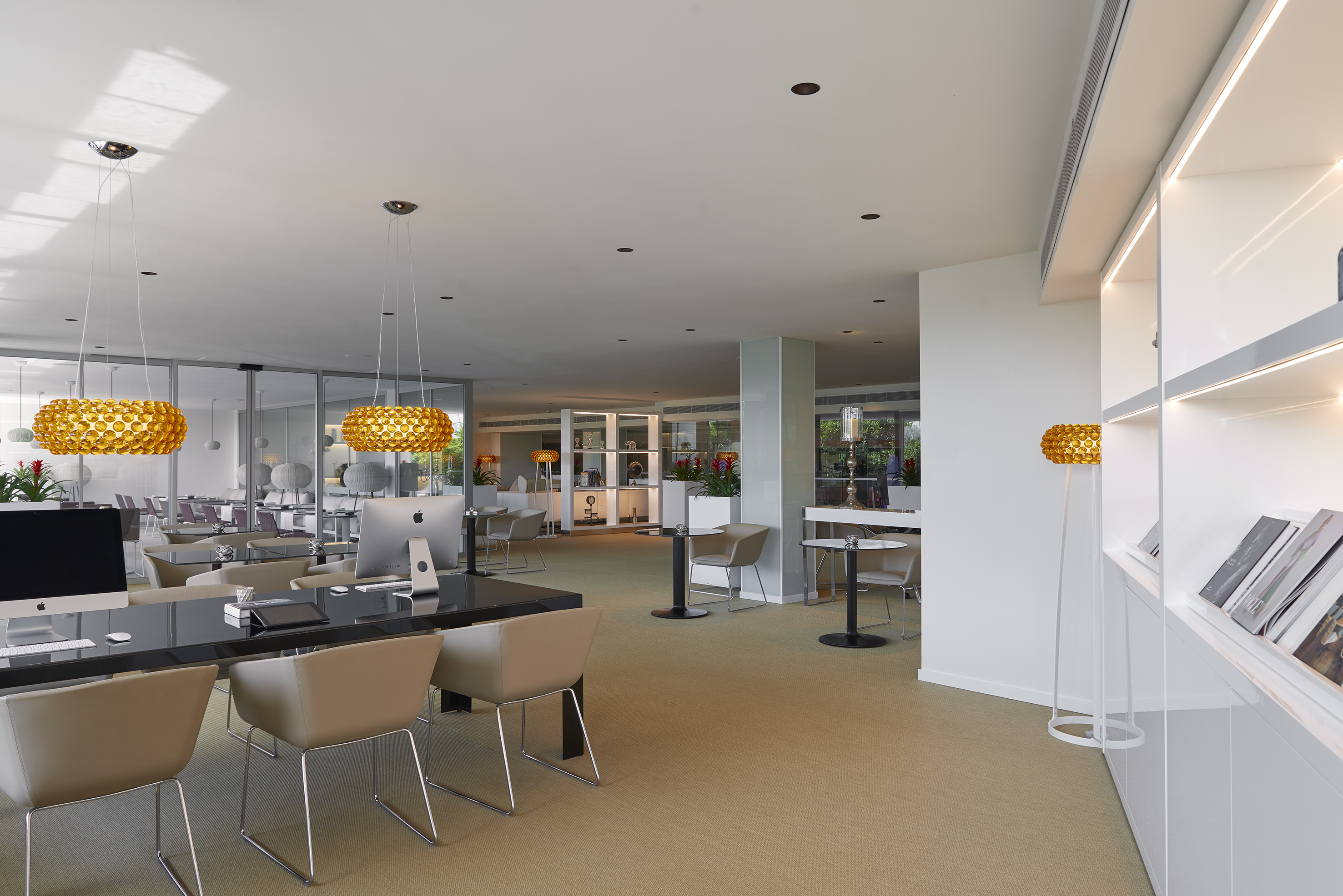Stylish modern lounge office with golden chandeliers and workstations.