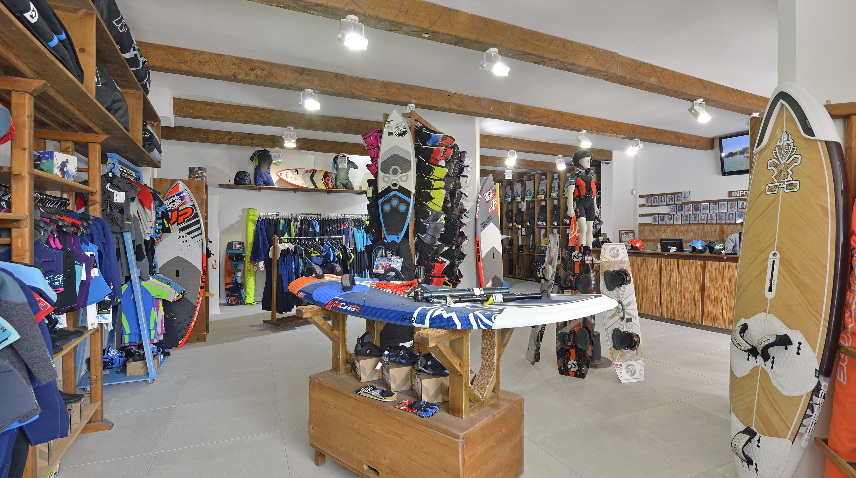 Surf and watersports shop with boards, wetsuits, and kiteboarding gear.