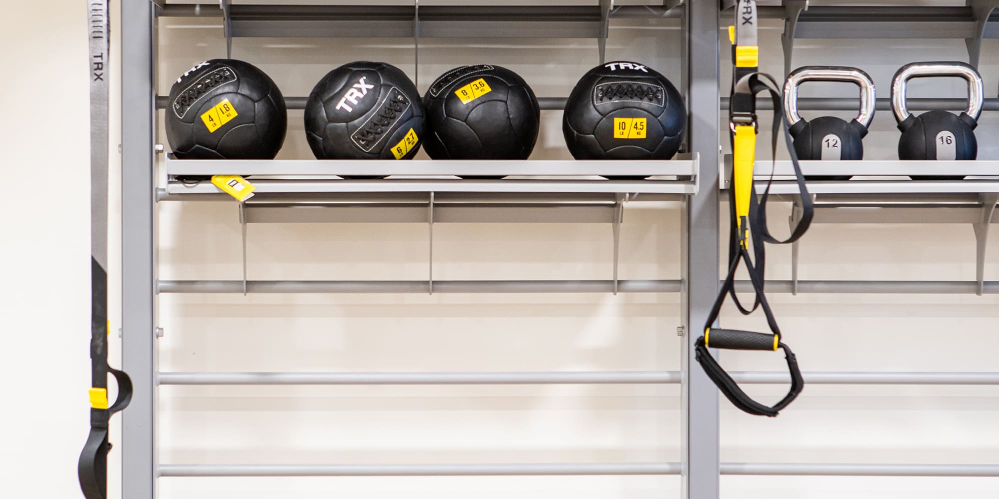 a wall with a rack with weights and balls