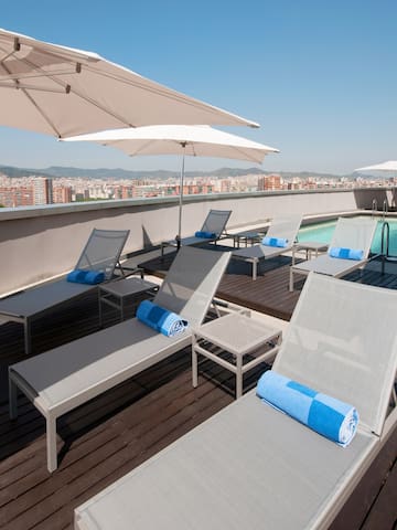 a pool with umbrellas and lounge chairs on a rooftop