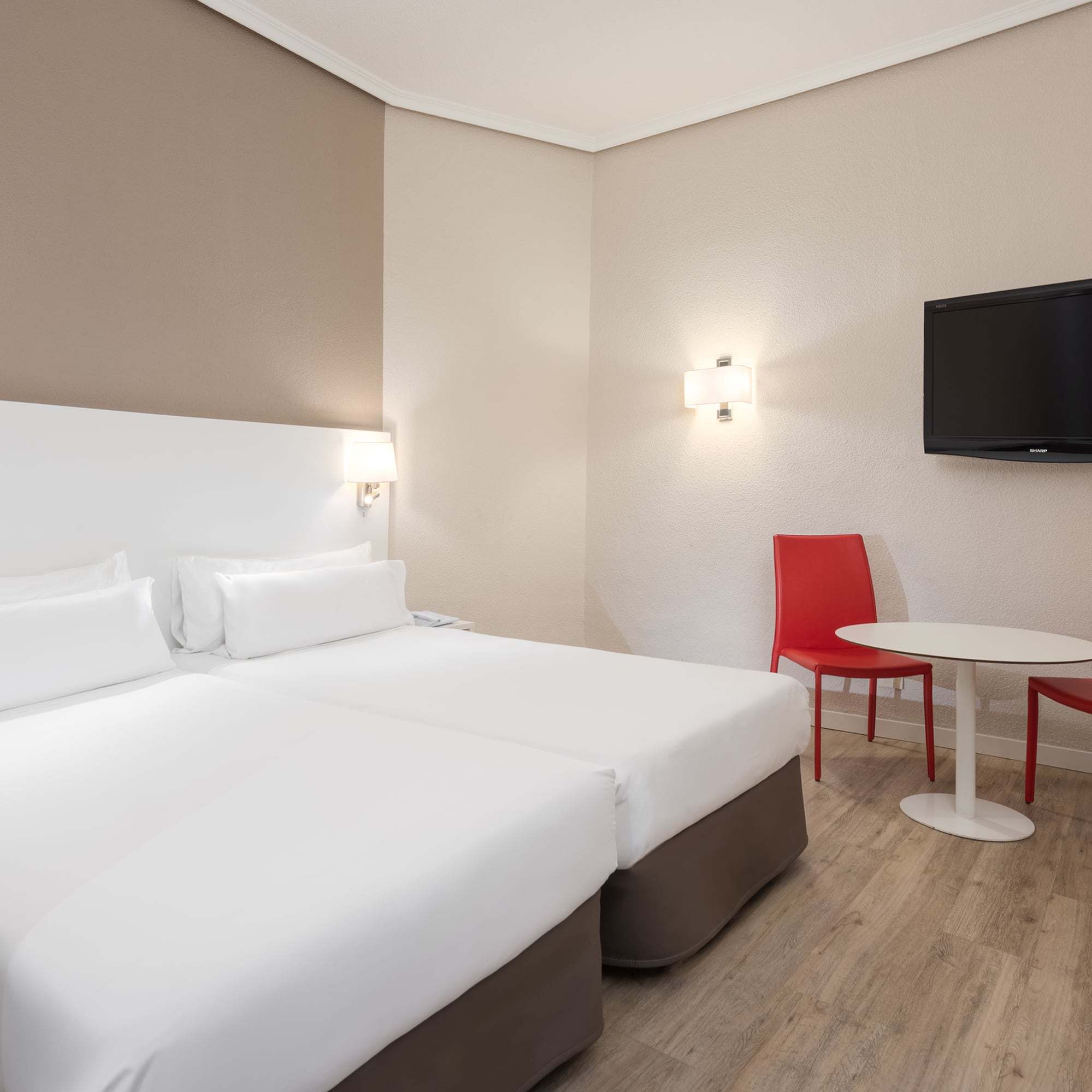 a room with two beds and a table and a tv