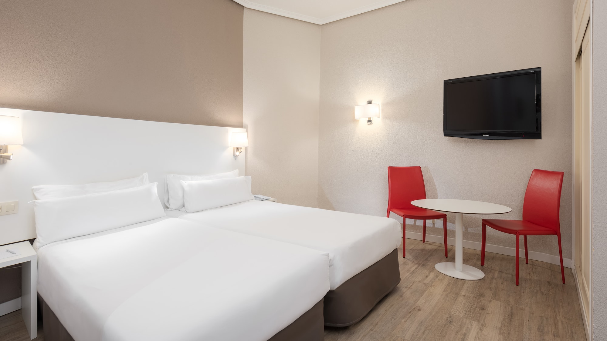 a room with two beds and a table and a tv