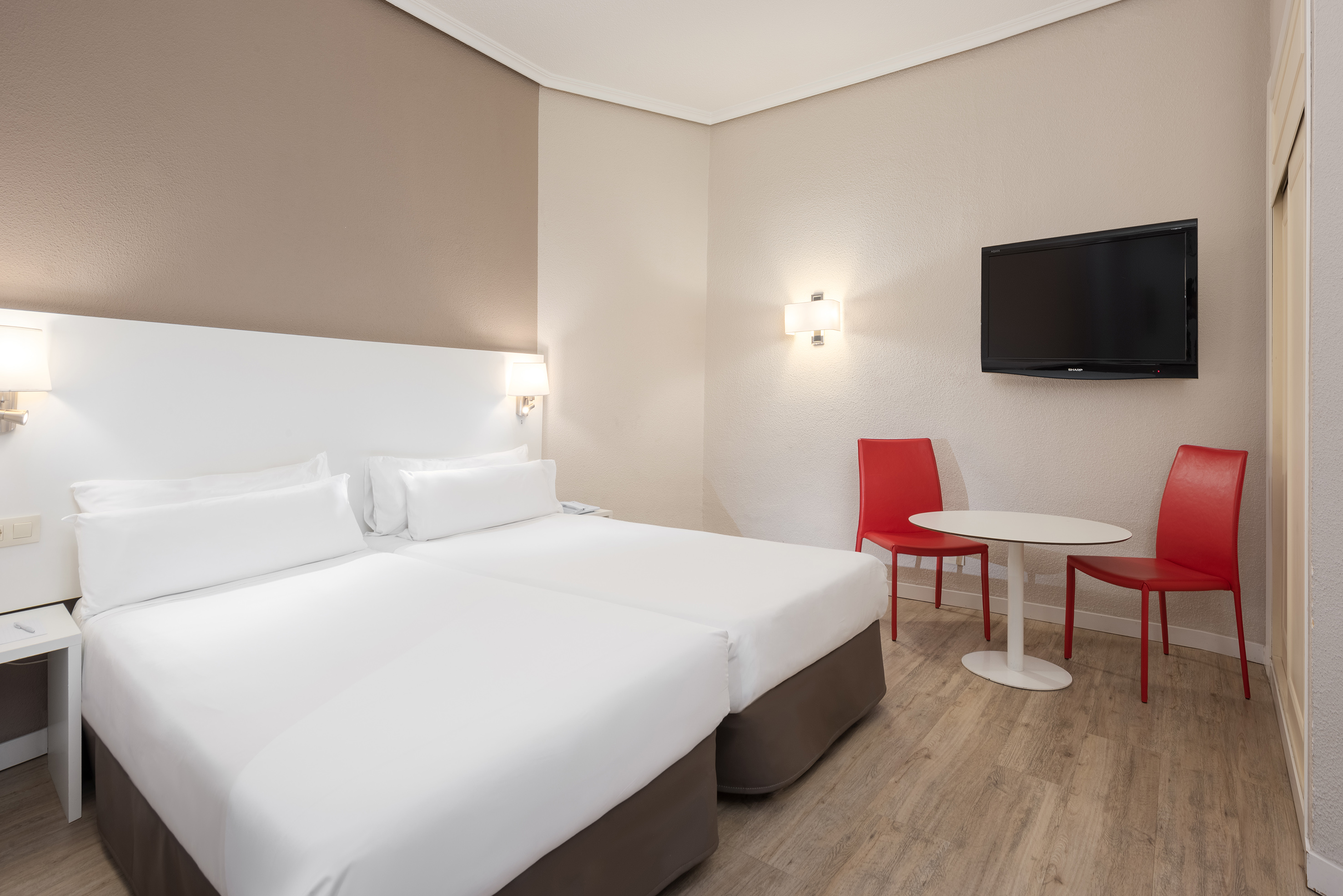 a room with two beds and a table and a tv