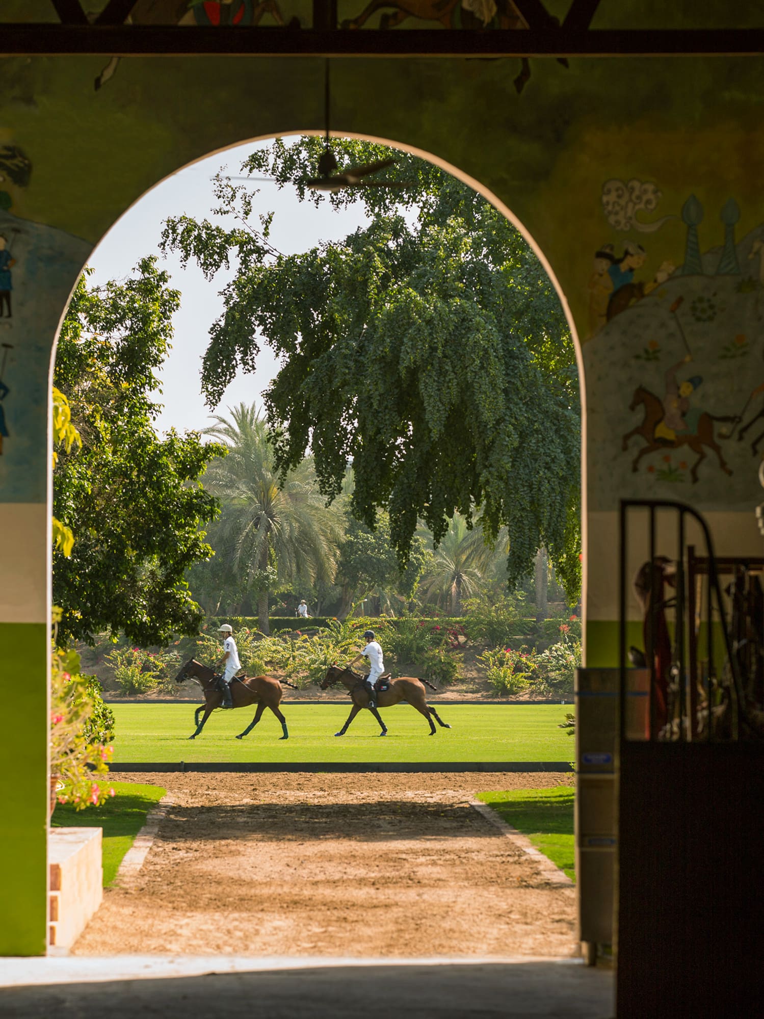 people riding horses in a grassy area