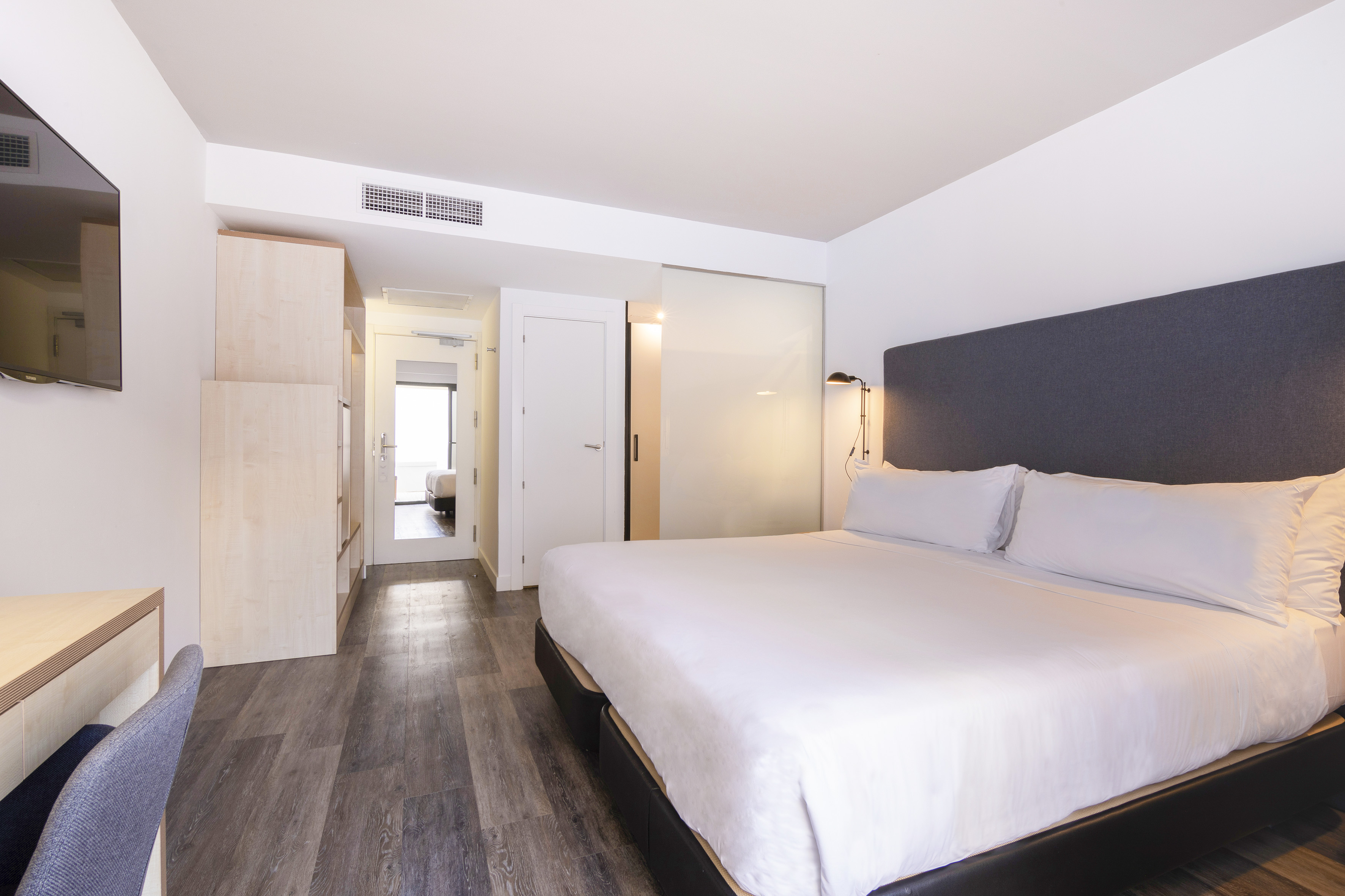 a bedroom with a bed and a wood floor