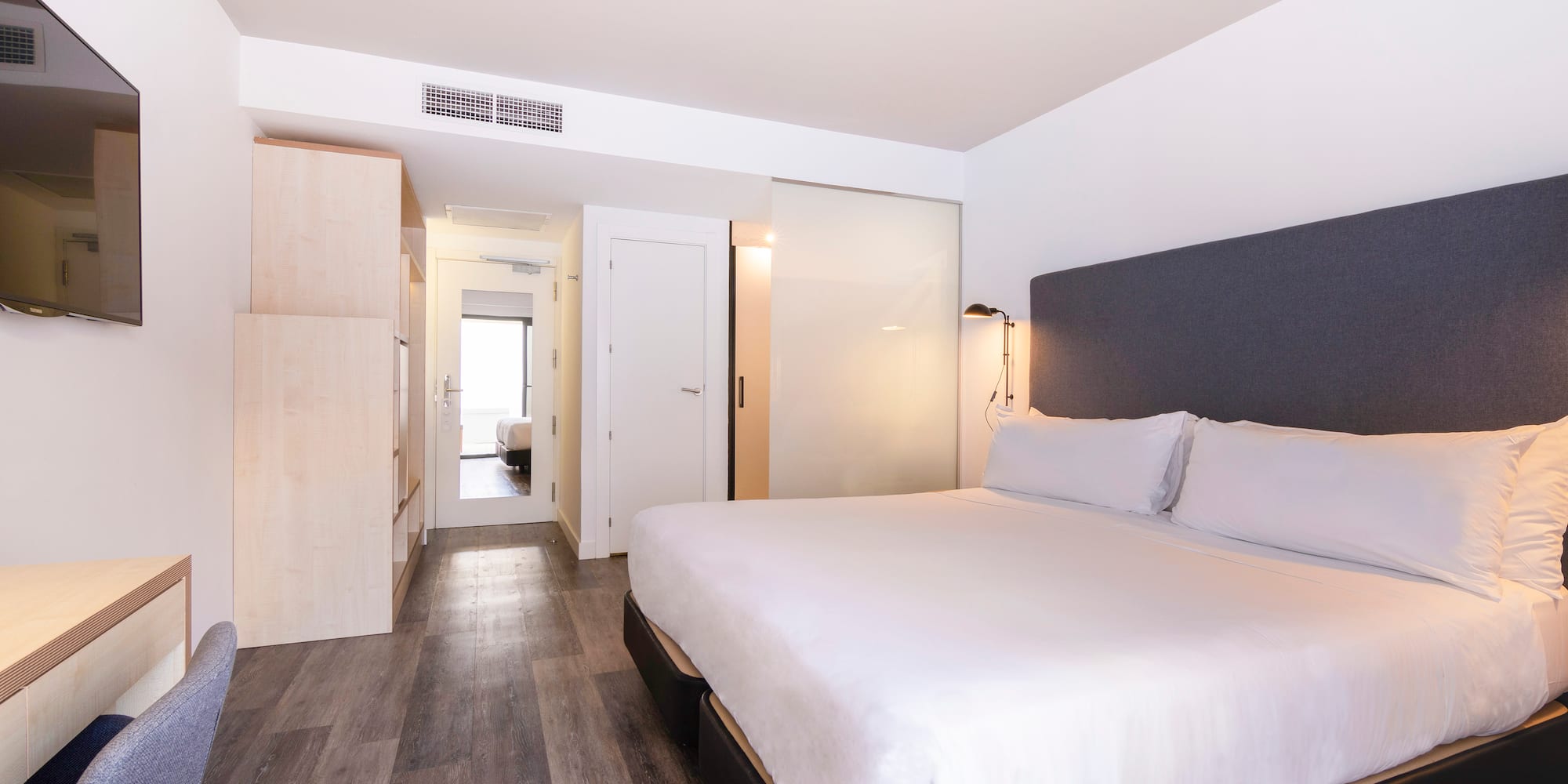 a bedroom with a bed and a wood floor