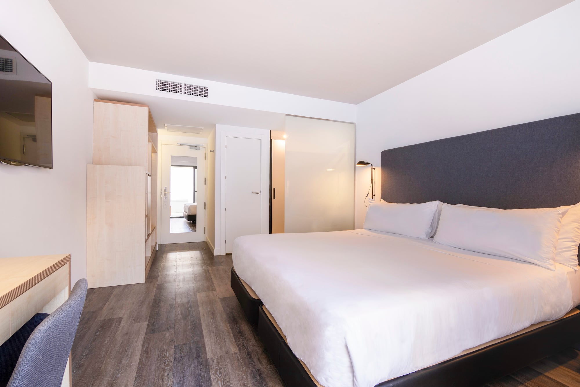 a bedroom with a bed and a wood floor