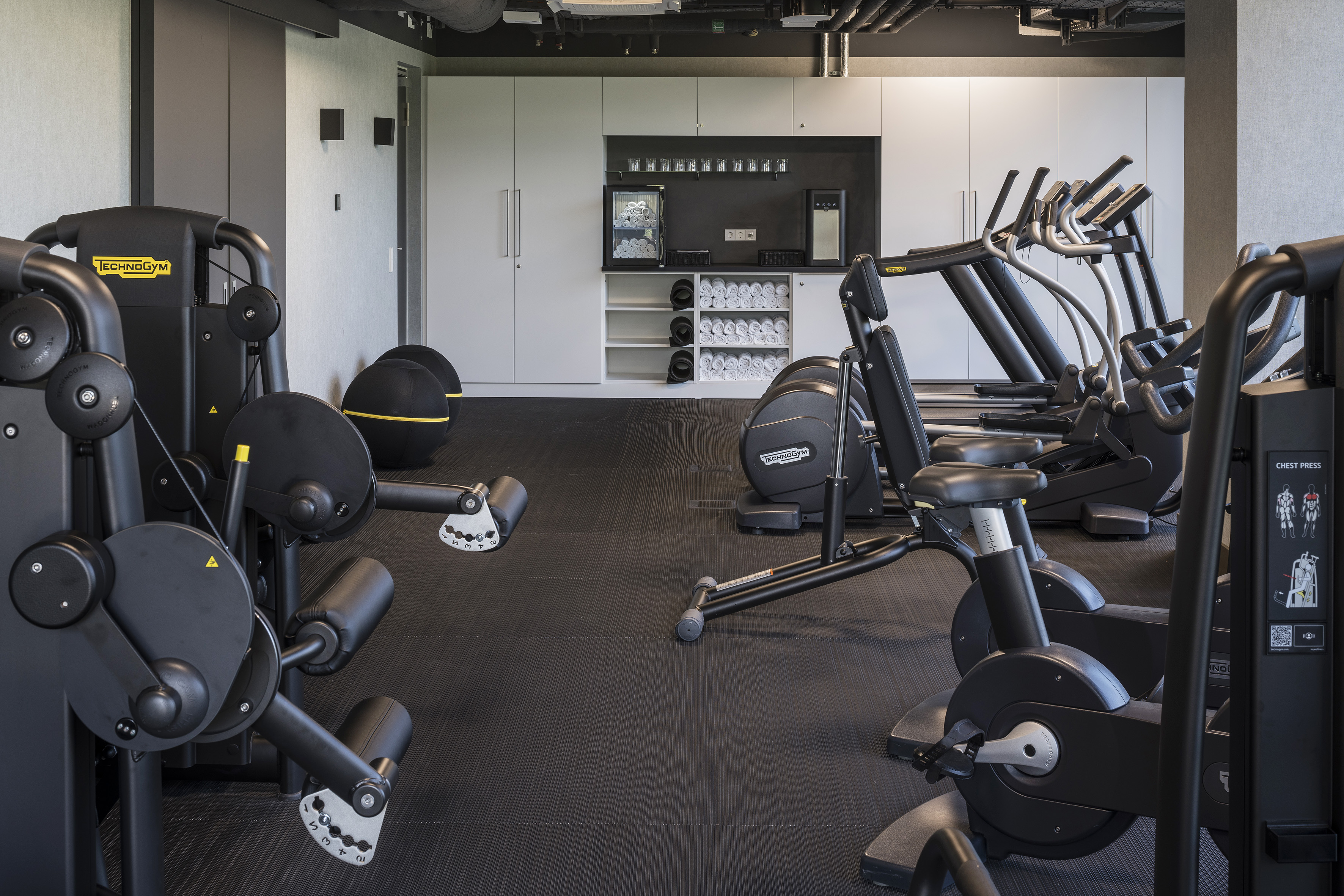 Fitness room featuring Technogym exercise machines and wellness amenities.