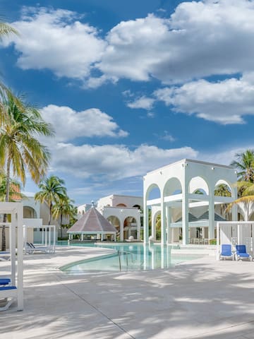 a pool with a gazebo and palm trees
