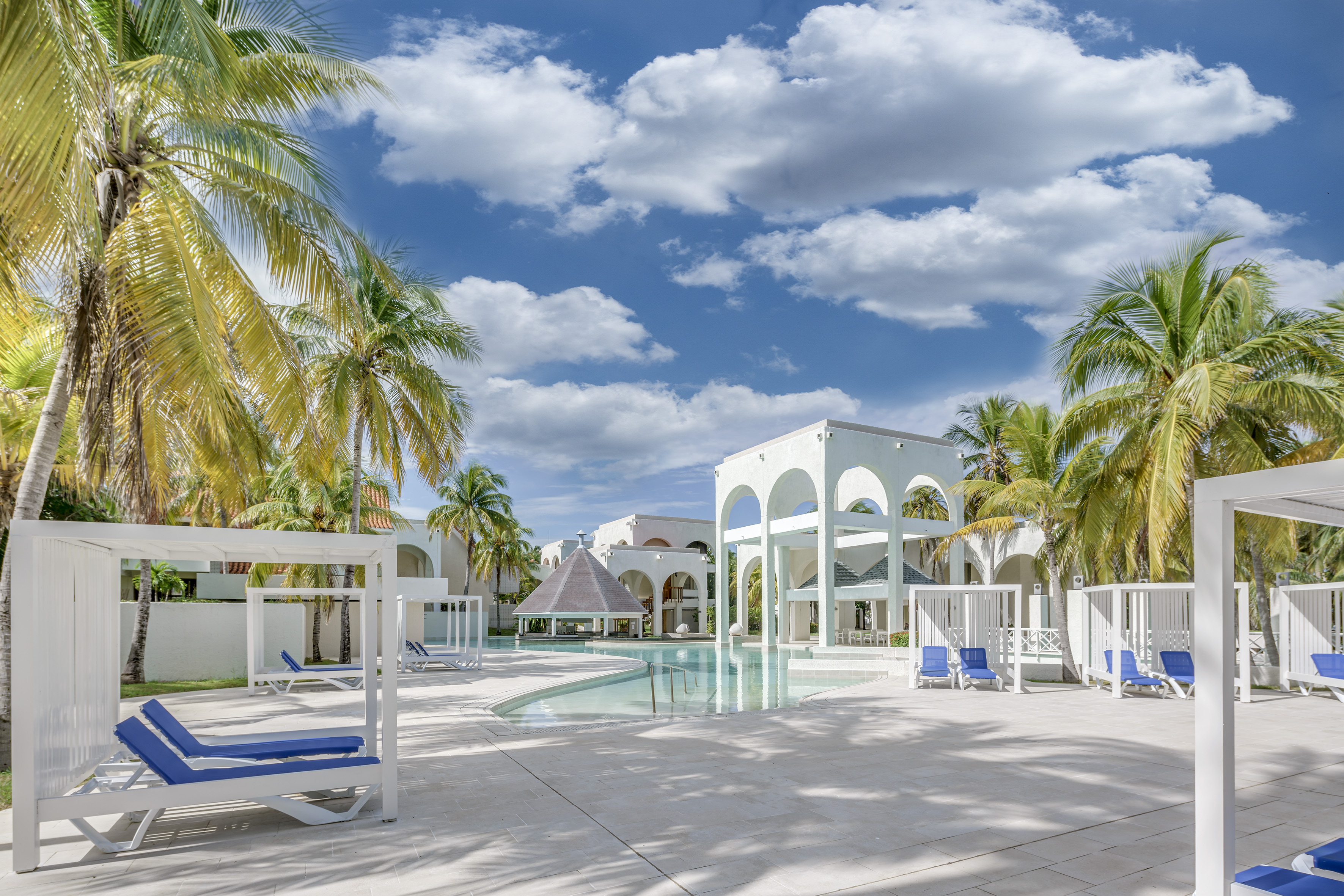 a pool with a gazebo and palm trees