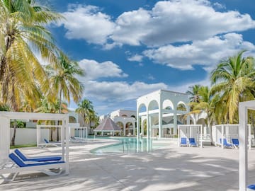 a pool with a gazebo and palm trees