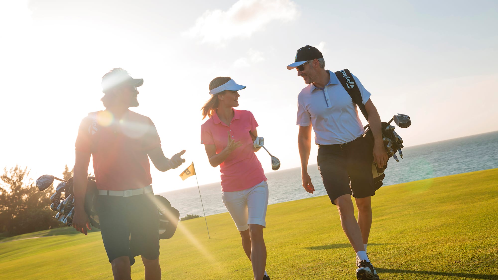 a group of people walking on a golf course
