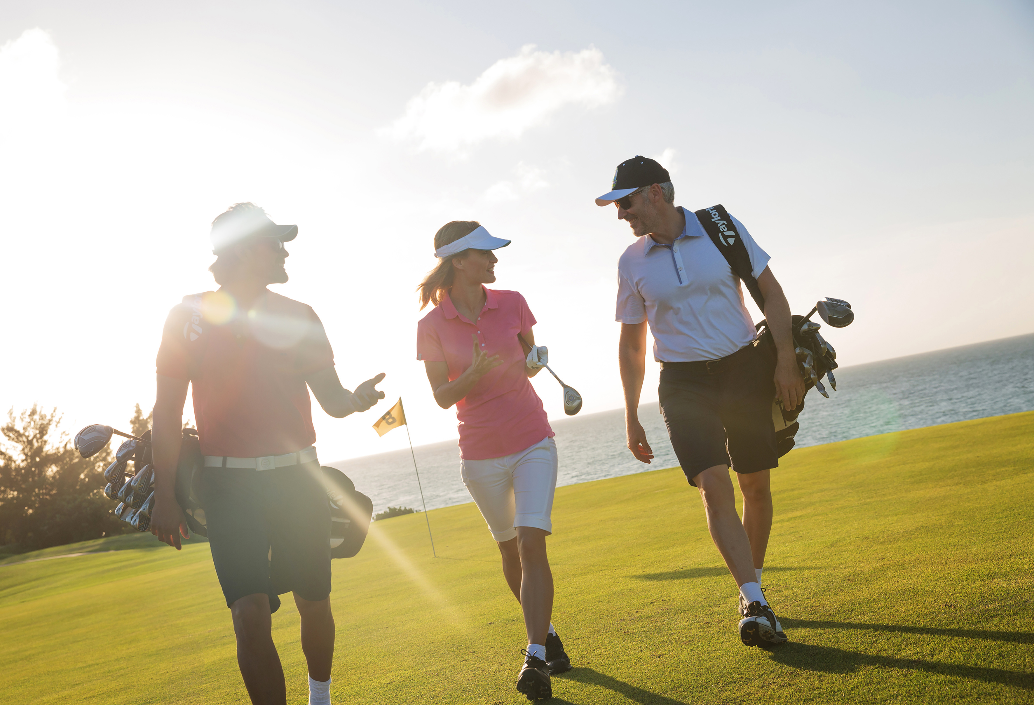 a group of people walking on a golf course