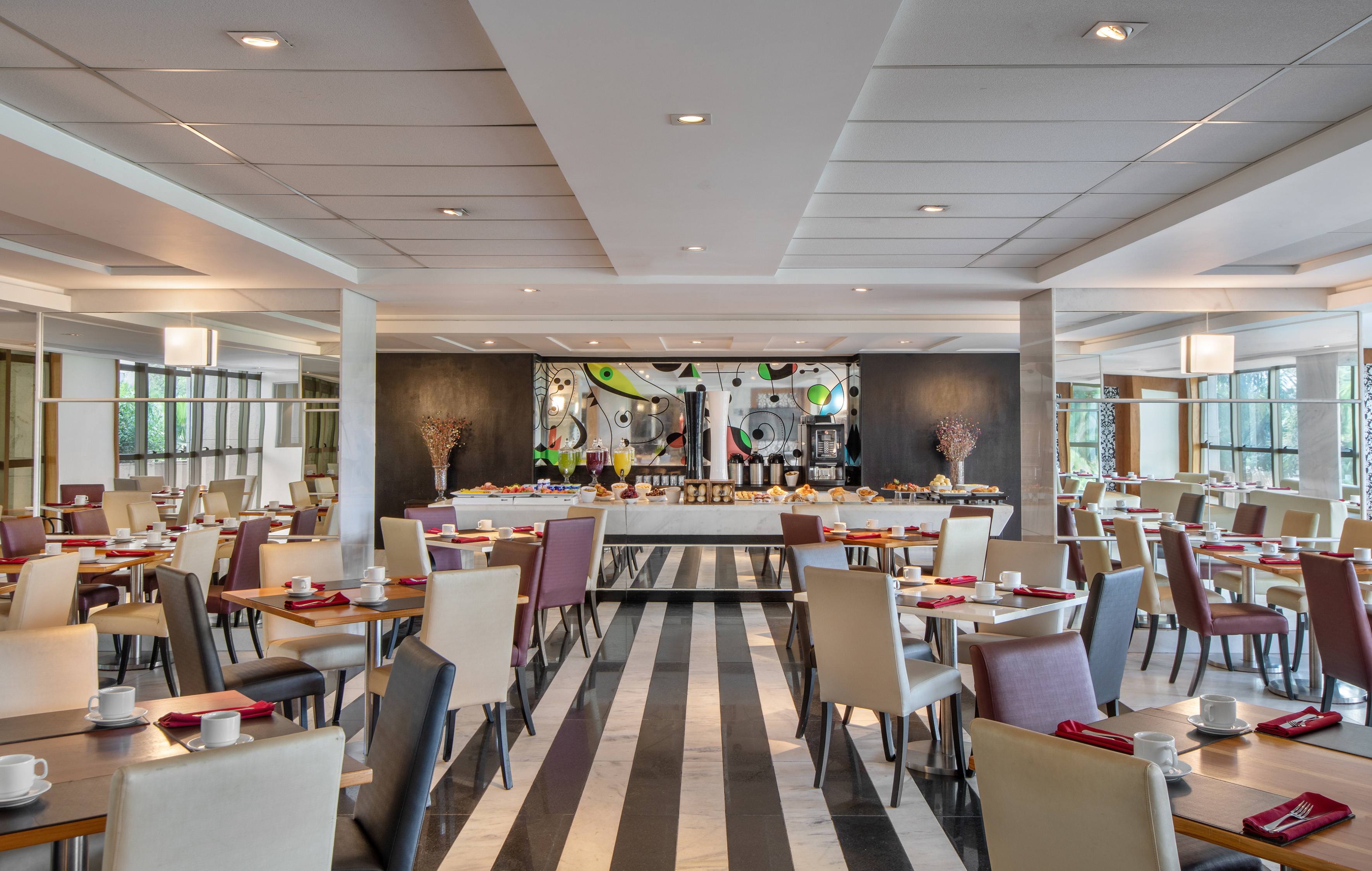 Elegant hotel restaurant with breakfast buffet and striped floor.