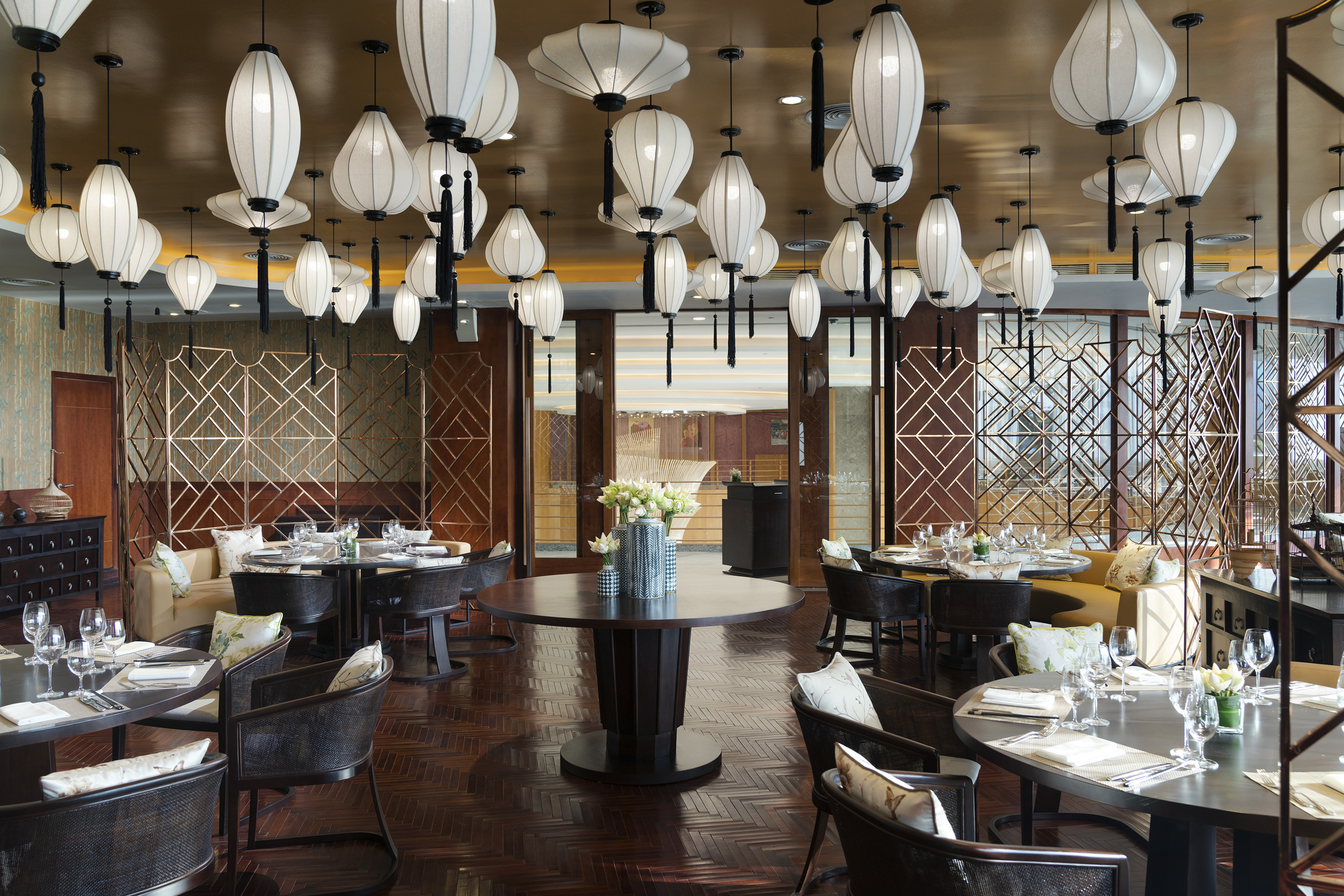 Elegant Asian restaurant dining room with white lanterns and dark wood tables.