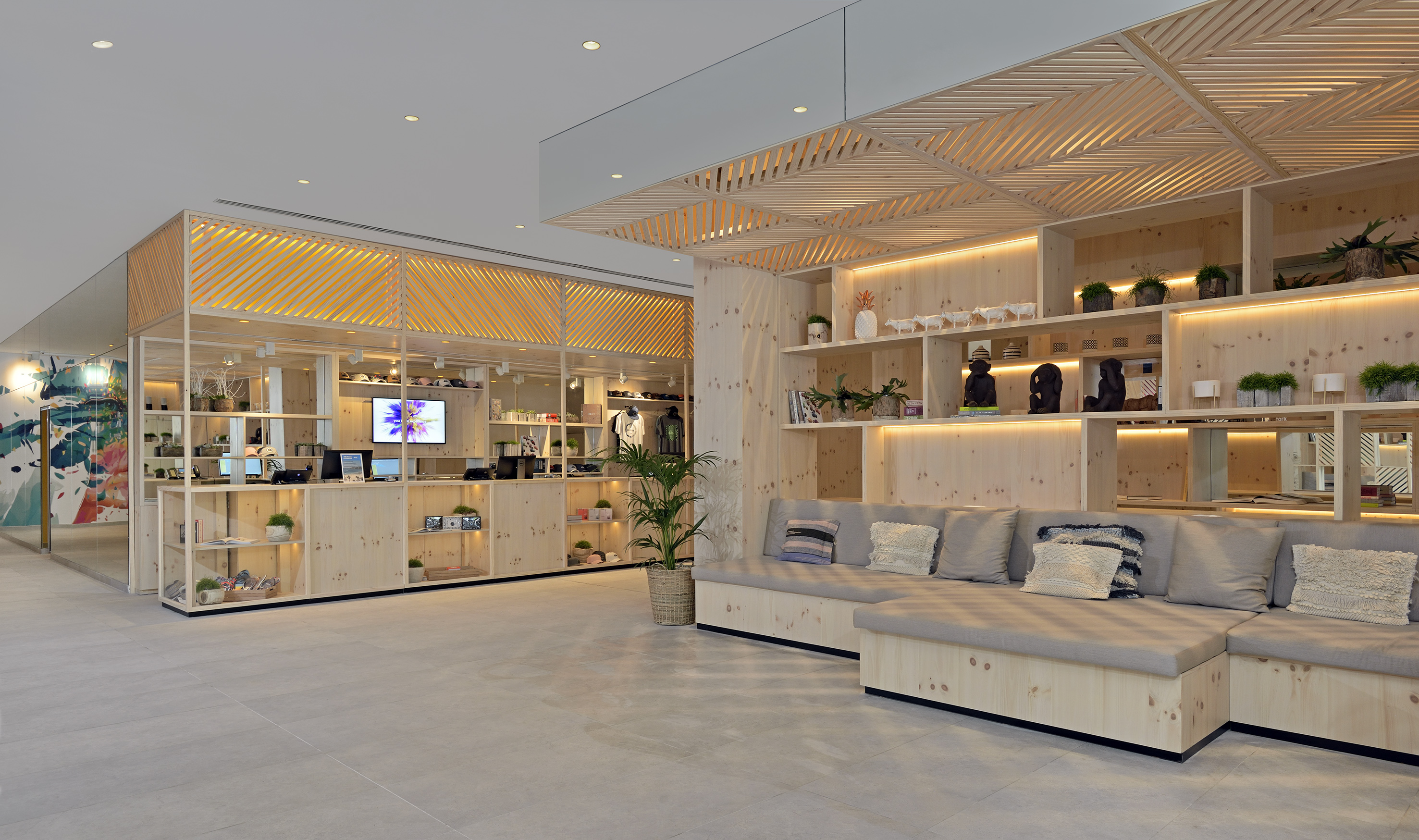 Bright modern retail interior with wooden shelves, built-in sofa, and products.