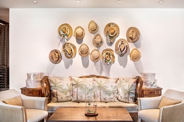 a room with a couch and hats on the wall