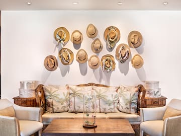a room with a couch and hats on the wall