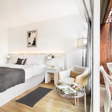 a bedroom with a bed and chairs