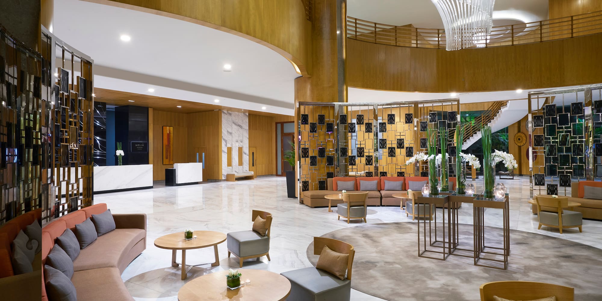 a lobby with a large chandelier and a large round table