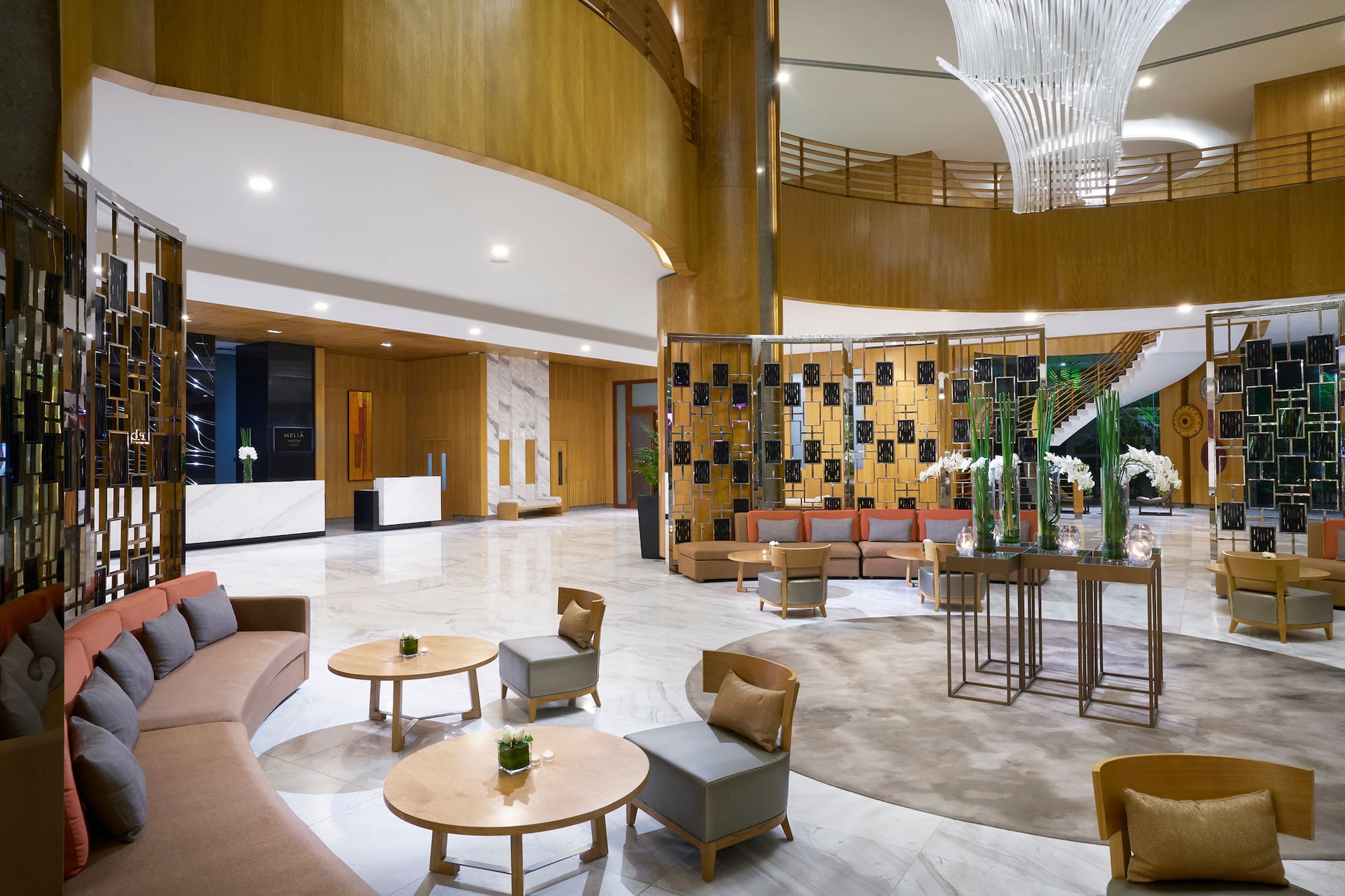 Meliã hotel lobby with modern seating, reception desk, and large chandelier.