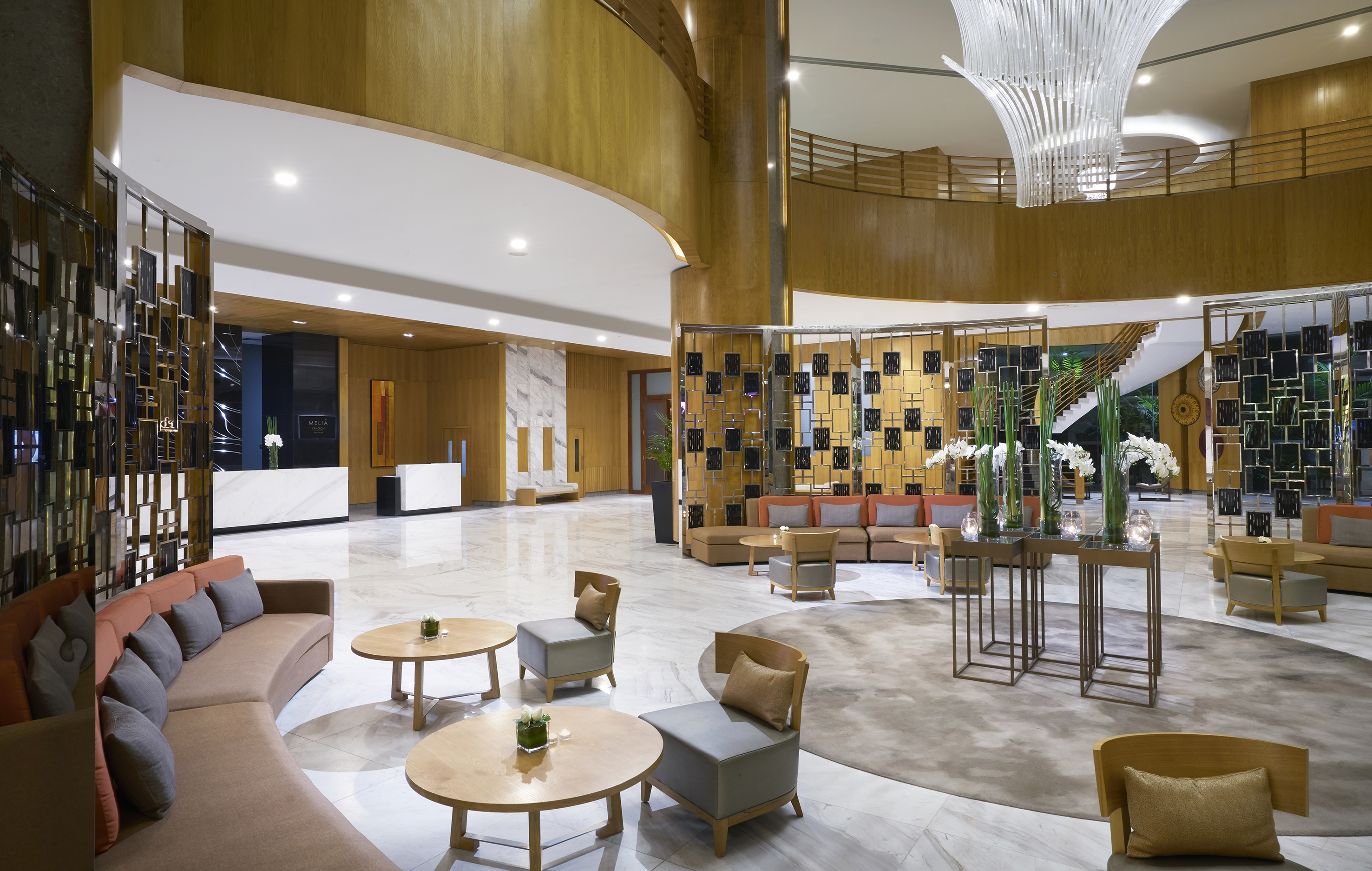 a lobby with a large chandelier and a large round table