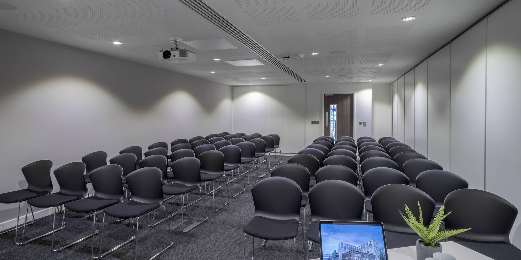 a room with many chairs and a laptop