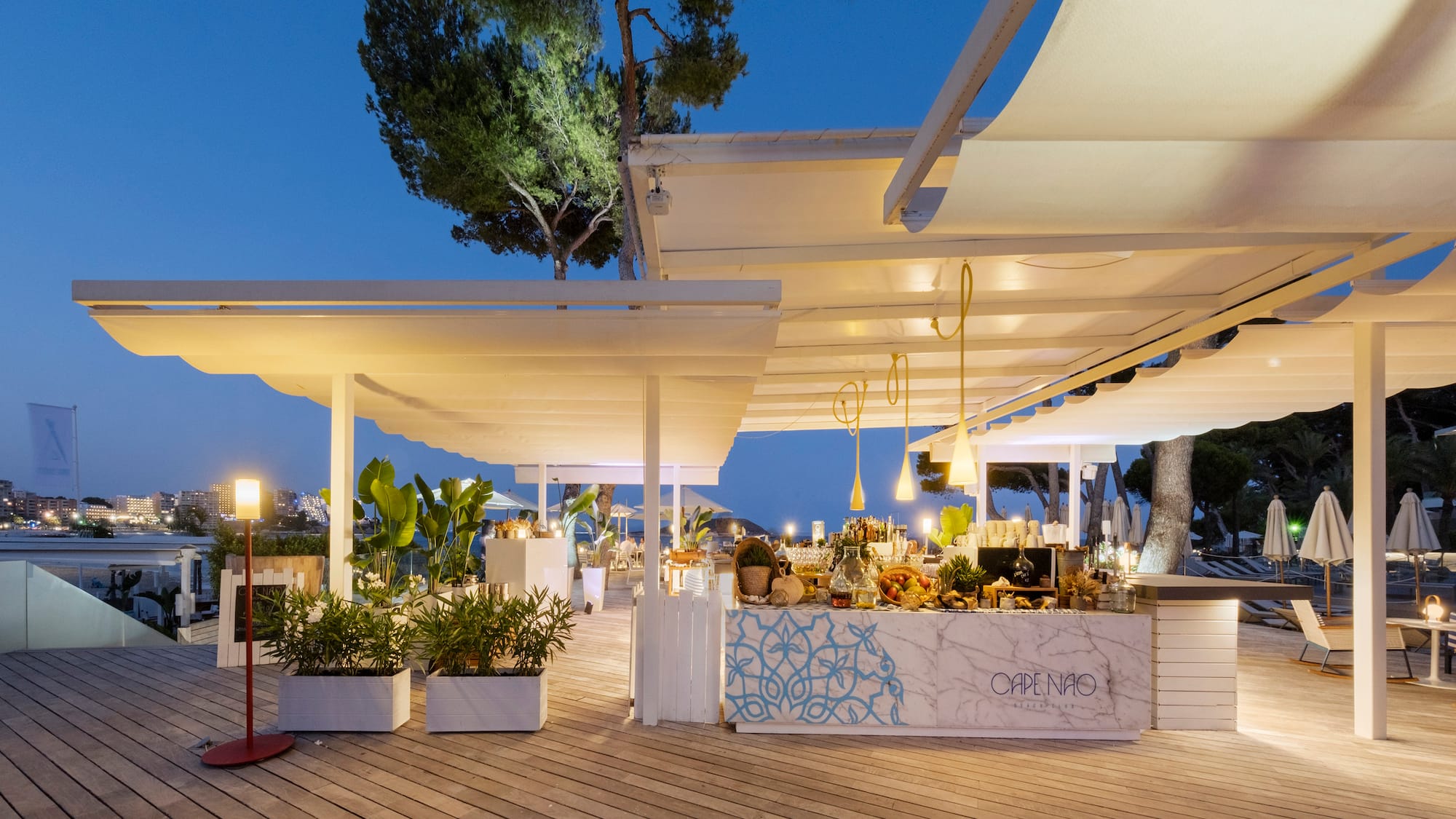 a white outdoor restaurant with a table and plants
