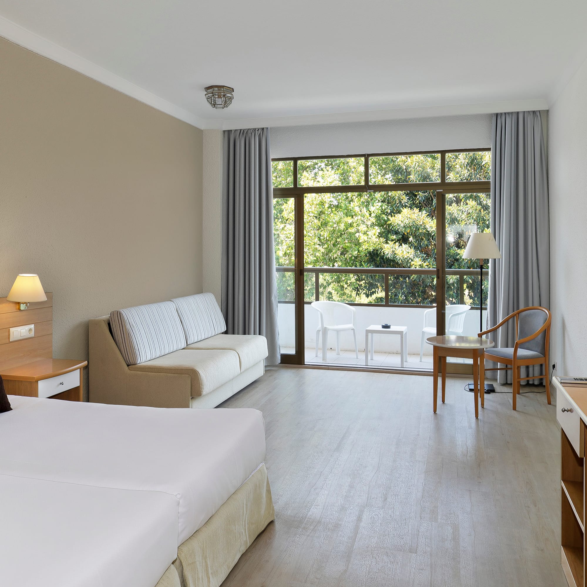 a room with two beds and a table and chairs