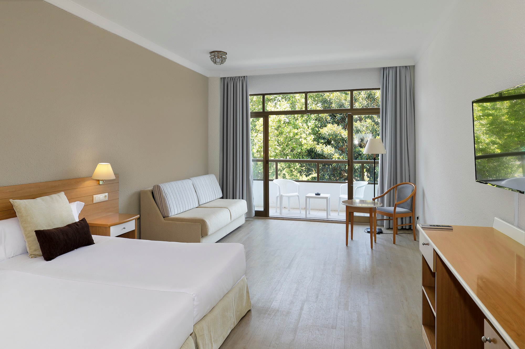 a room with two beds and a table and chairs