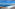 Panoramic ocean view from a hotel balcony over a coastal town and sea stack.