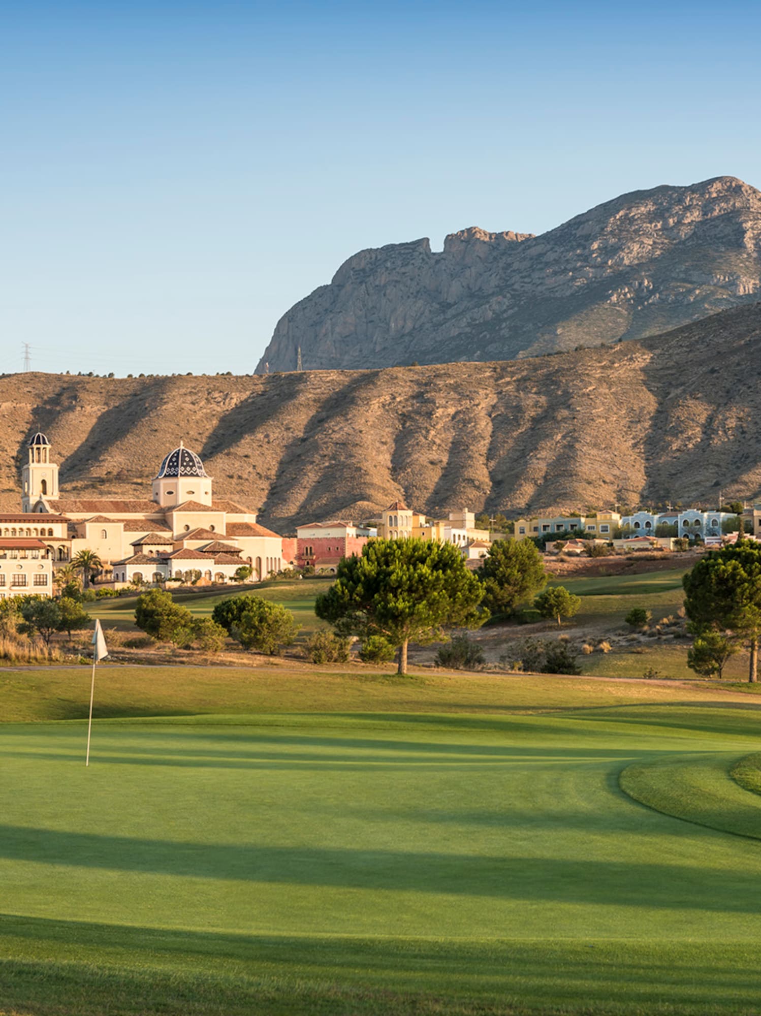 a golf course with a mountain in the background