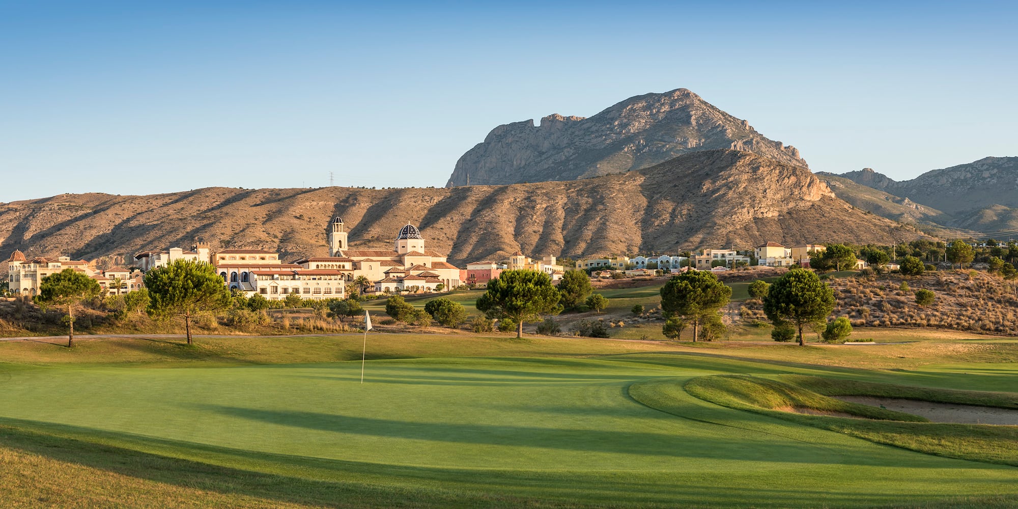 a golf course with a mountain in the background