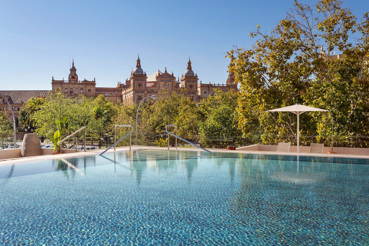 a pool with trees and buildings in the background