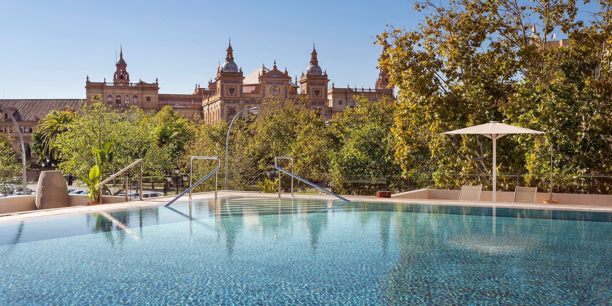 a pool with trees and buildings in the background