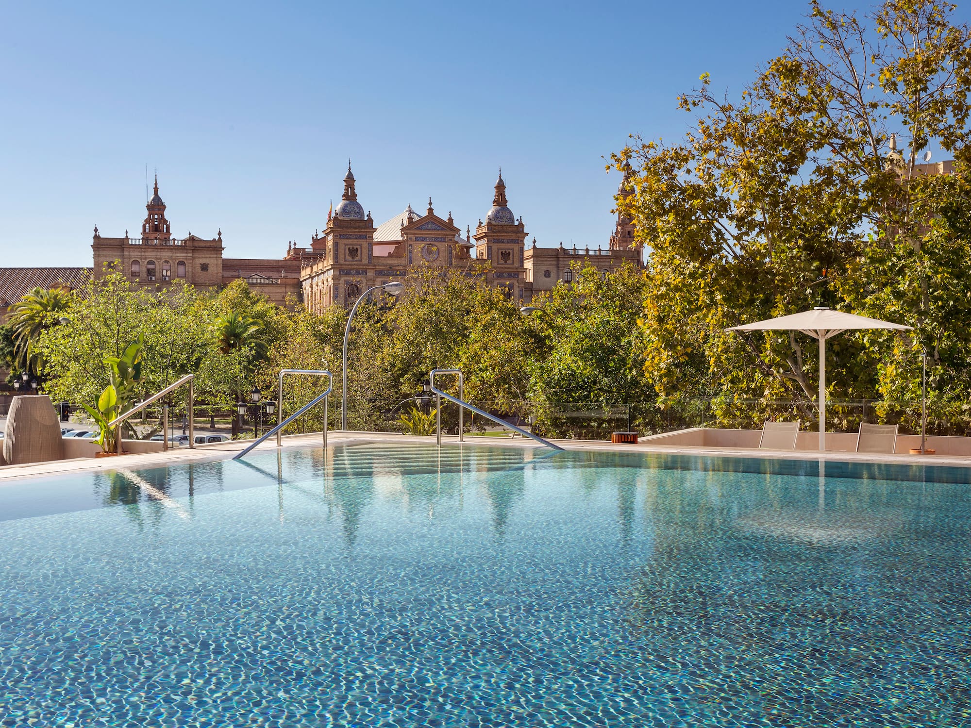 a pool with trees and buildings in the background