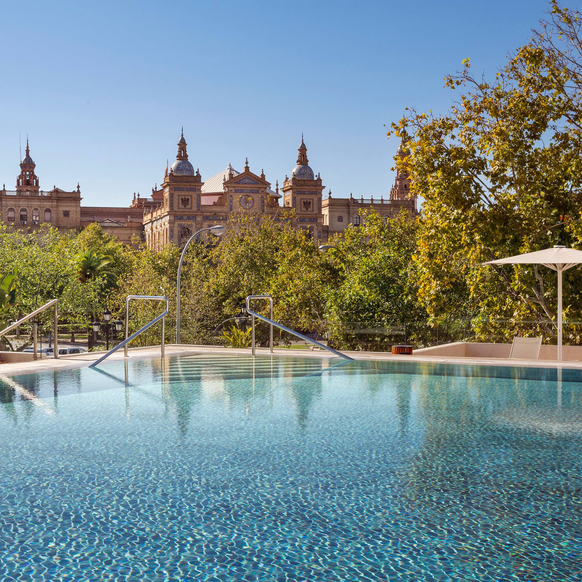 a pool with trees and buildings in the background