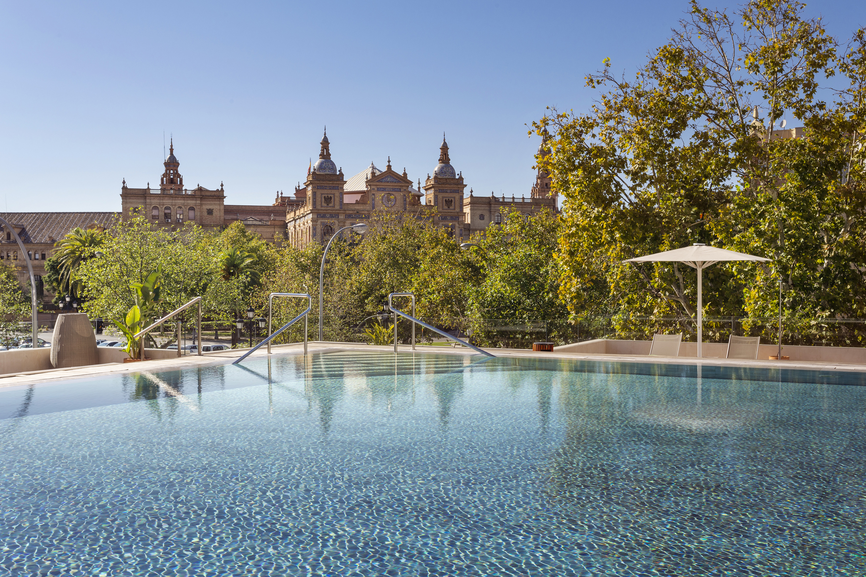 a pool with trees and buildings in the background