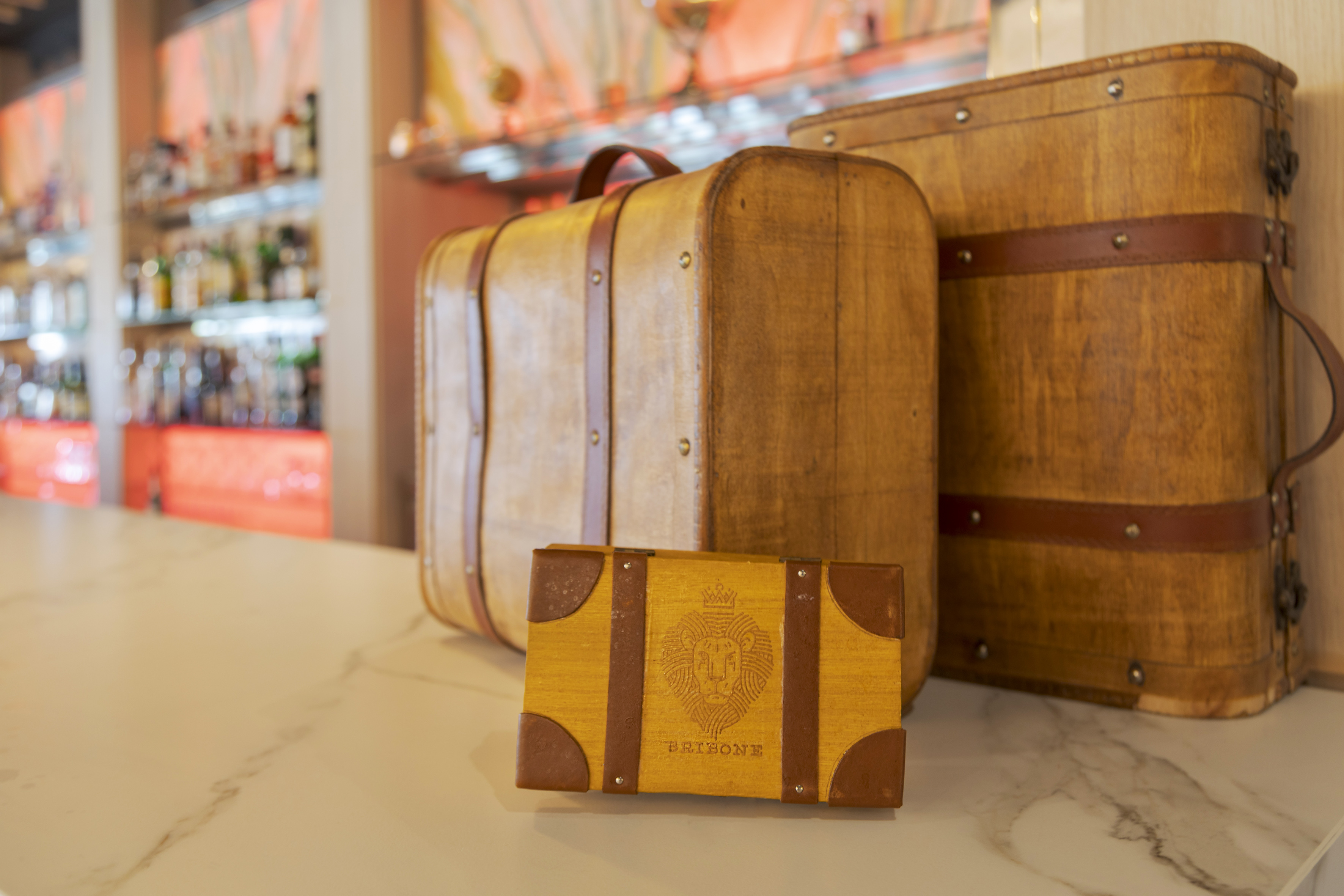 Vintage wooden travel suitcases, BRIBONE logo, on bar counter.