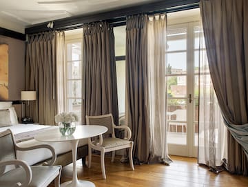 a room with a bed and chairs and a table