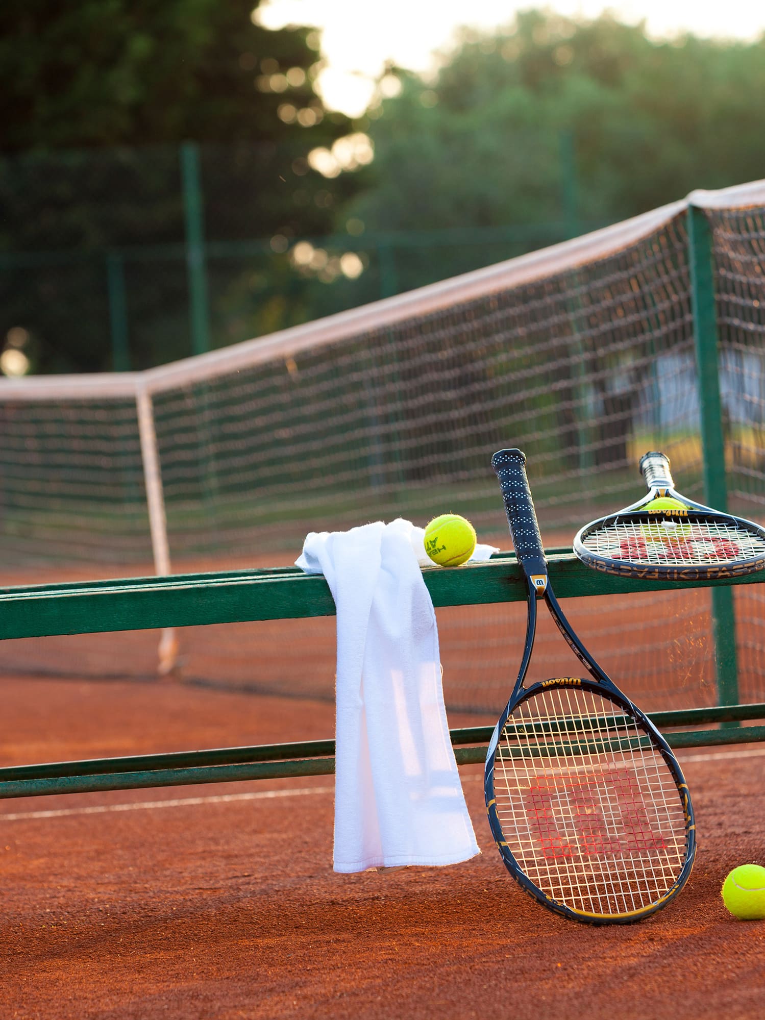 a tennis rackets and balls on a bench