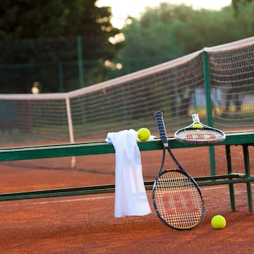 a tennis rackets and balls on a bench