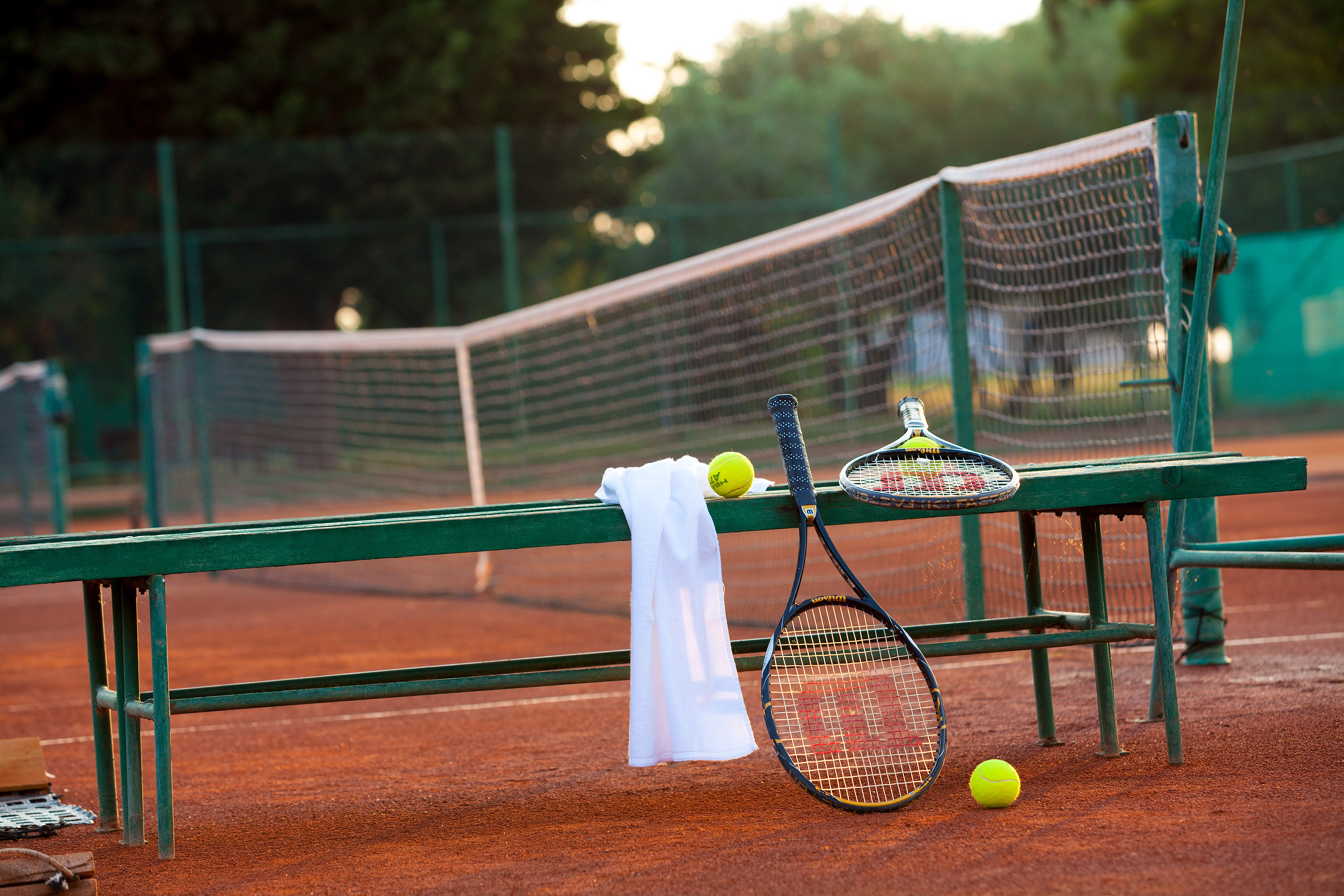 a tennis rackets and balls on a bench