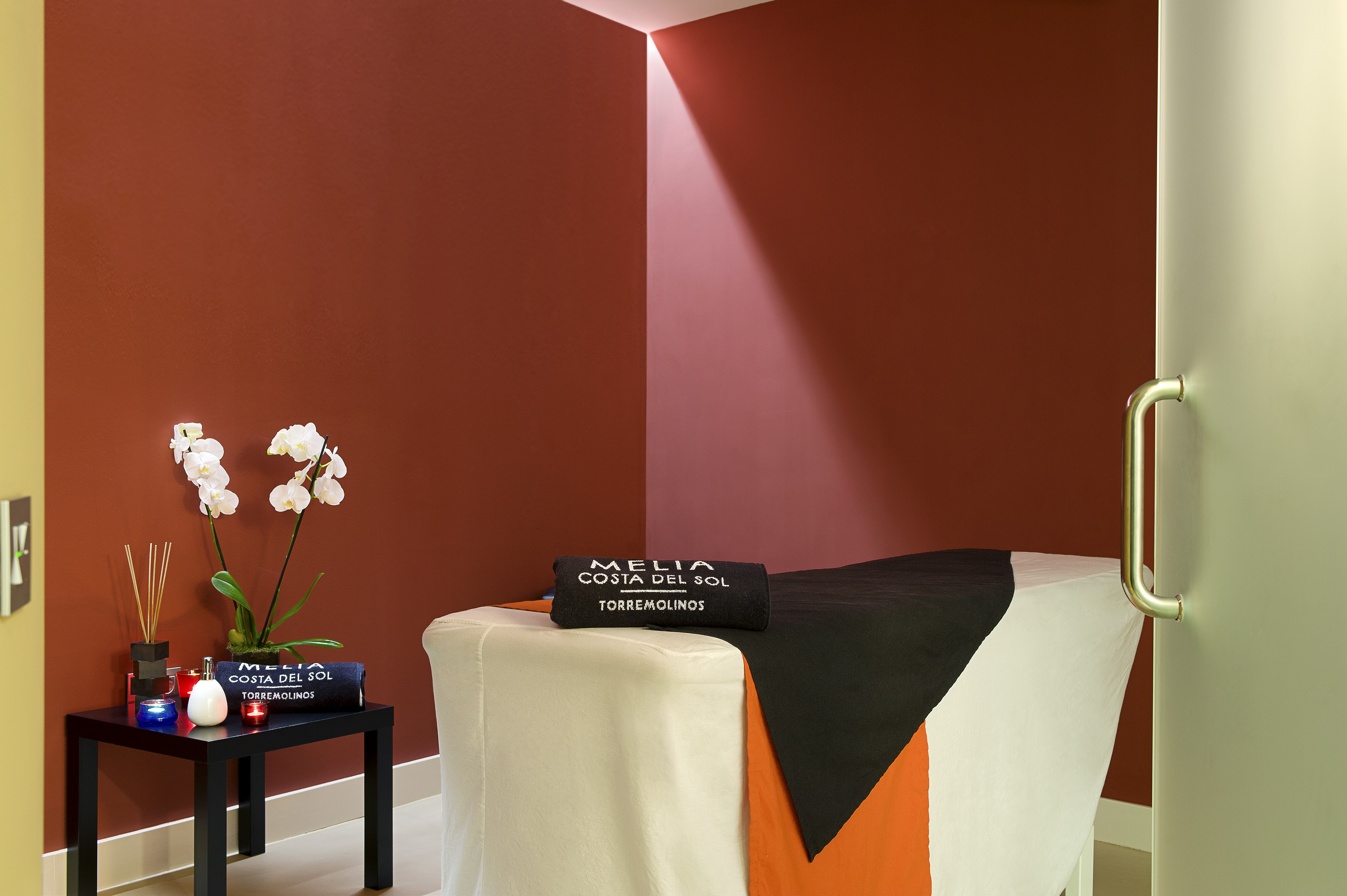 a massage table with a black towel and white and orange cloth