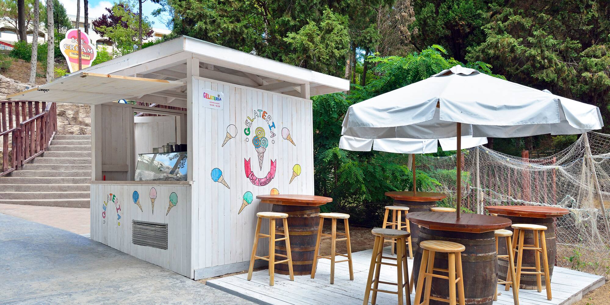 a white building with tables and umbrellas