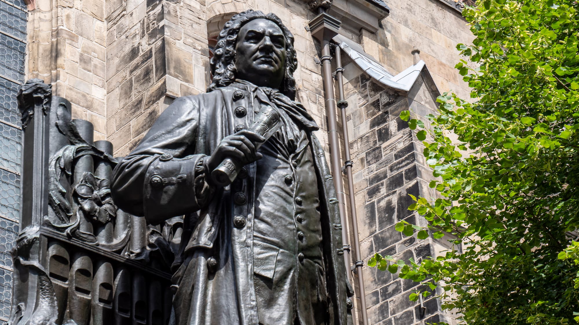a statue of a man in a coat outside of a building