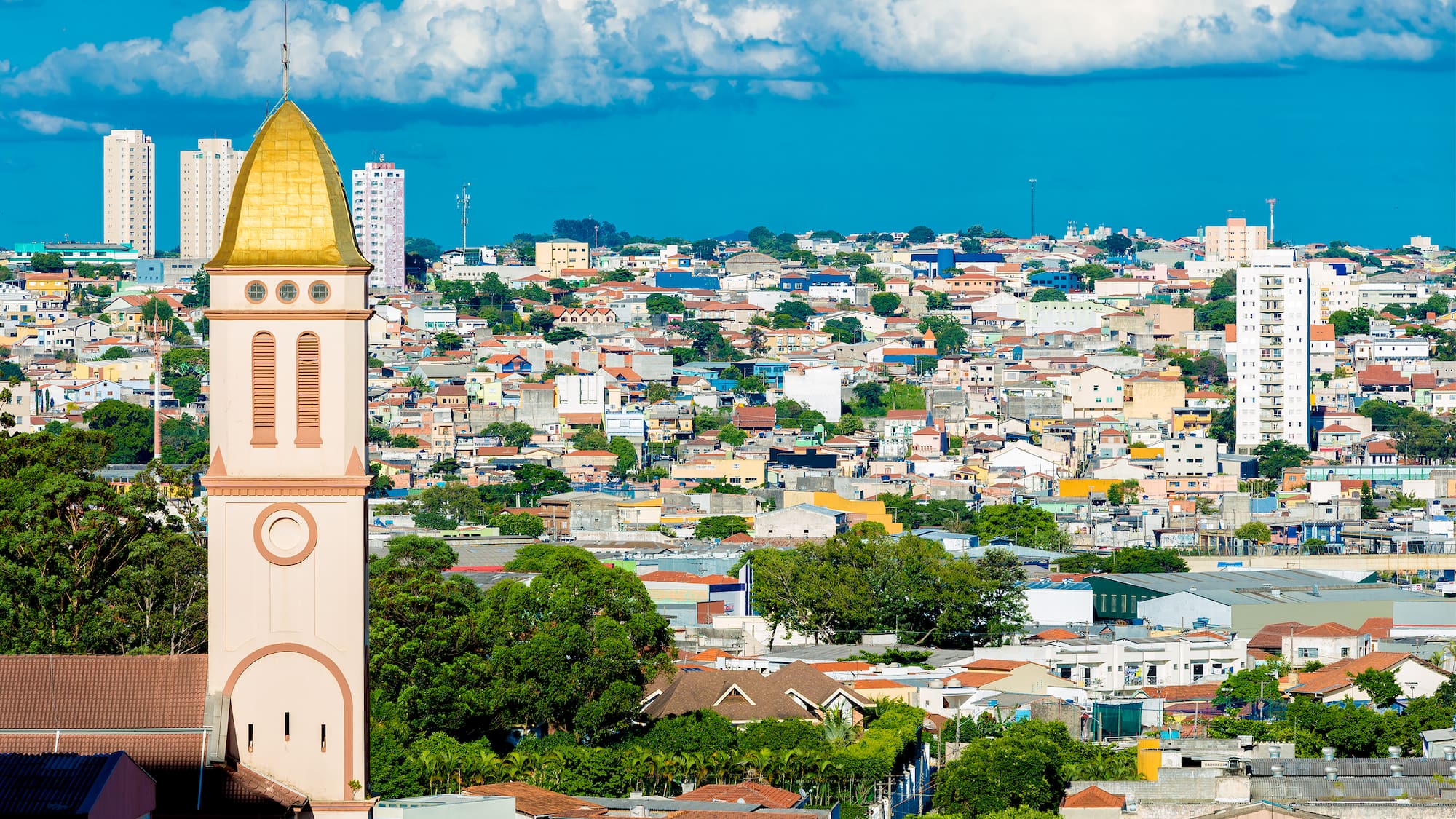 a tall building with a gold roof and a city landscape