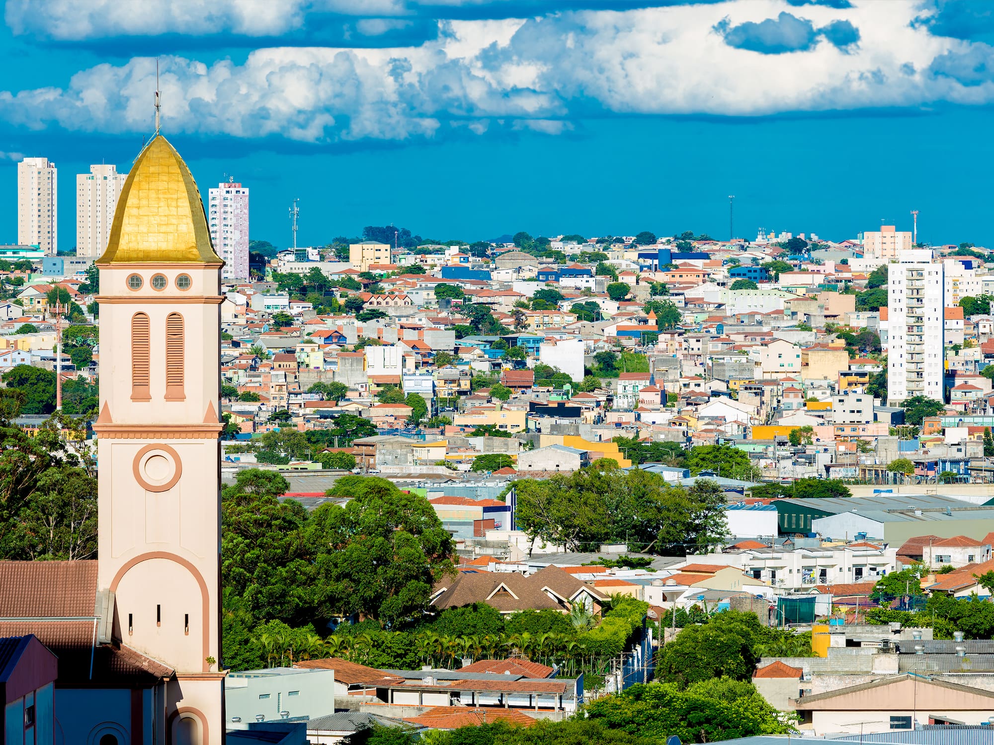 a tall building with a gold roof and a city landscape