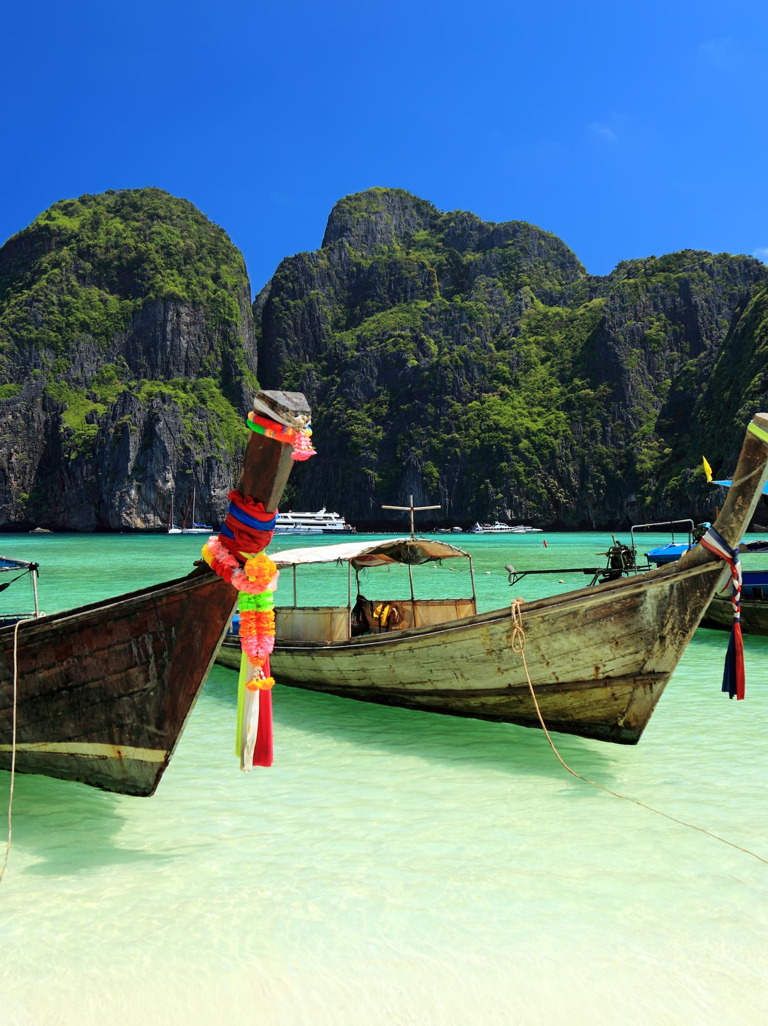 boats in the water with mountains in the background with Phi Phi Islands in the background